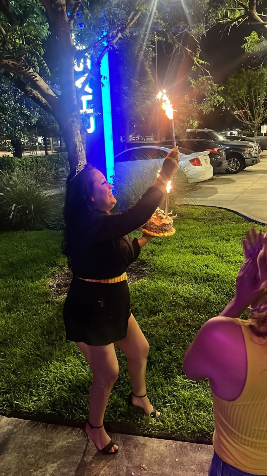 A rider holding a sparkler-topped cake on a night tour