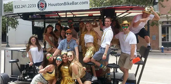 A costumed group posing beside the bike bar in gold outfits