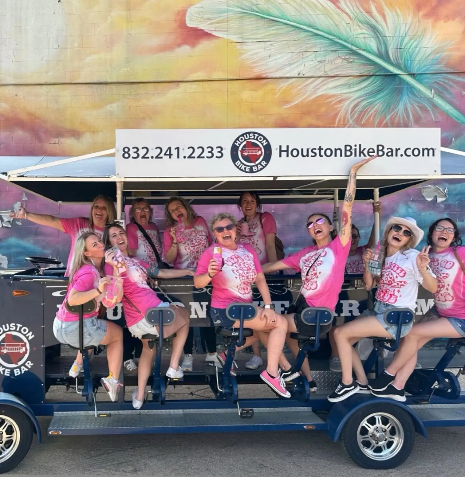 A group in pink shirts riding the bike bar