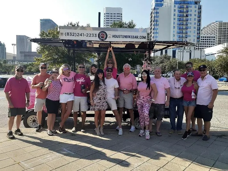 A group in pink cowboy hats riding the bike bar in Midtown